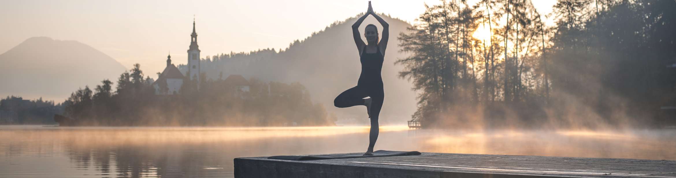 Junge Frau in Yoga Baum Pose auf Pier mit Blick auf Lake Bled, Foto: AzmanL, stock Foto ID: 1184503070