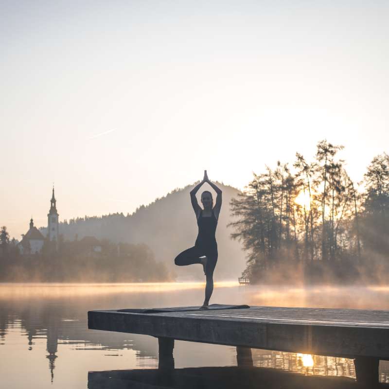 Junge Frau in Yoga Baum Pose auf Pier mit Blick auf Lake Bled, Foto: AzmanL, stock Foto ID: 1184503070